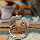 Handcrafted sterling silver ring by Allen Chee featuring an oval natural turquoise cabochon with dark matrix, surrounded by detailed feather motifs, silver scrollwork, twisted wire, and bead accents; artisan and Sterling Silver stamp.