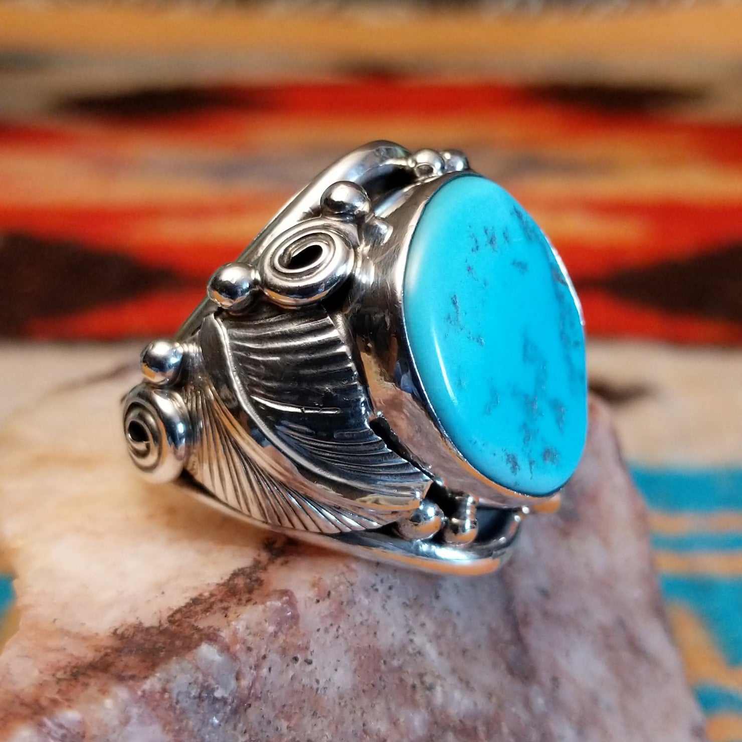 Sterling silver ring with Kingman turquoise set in the bezel, framed by unique silverwork designs.
