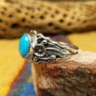 Turquoise ring with detailed sterling silver band by Raymond Coriz, featuring a vibrant blue turquoise stone with natural matrix set in a handcrafted sterling silver ring with intricate band detailing.  Side view.