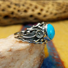 Turquoise ring with detailed sterling silver band by Raymond Coriz, featuring a vibrant blue turquoise stone with natural matrix set in a handcrafted sterling silver ring with intricate band detailing.  Side view.