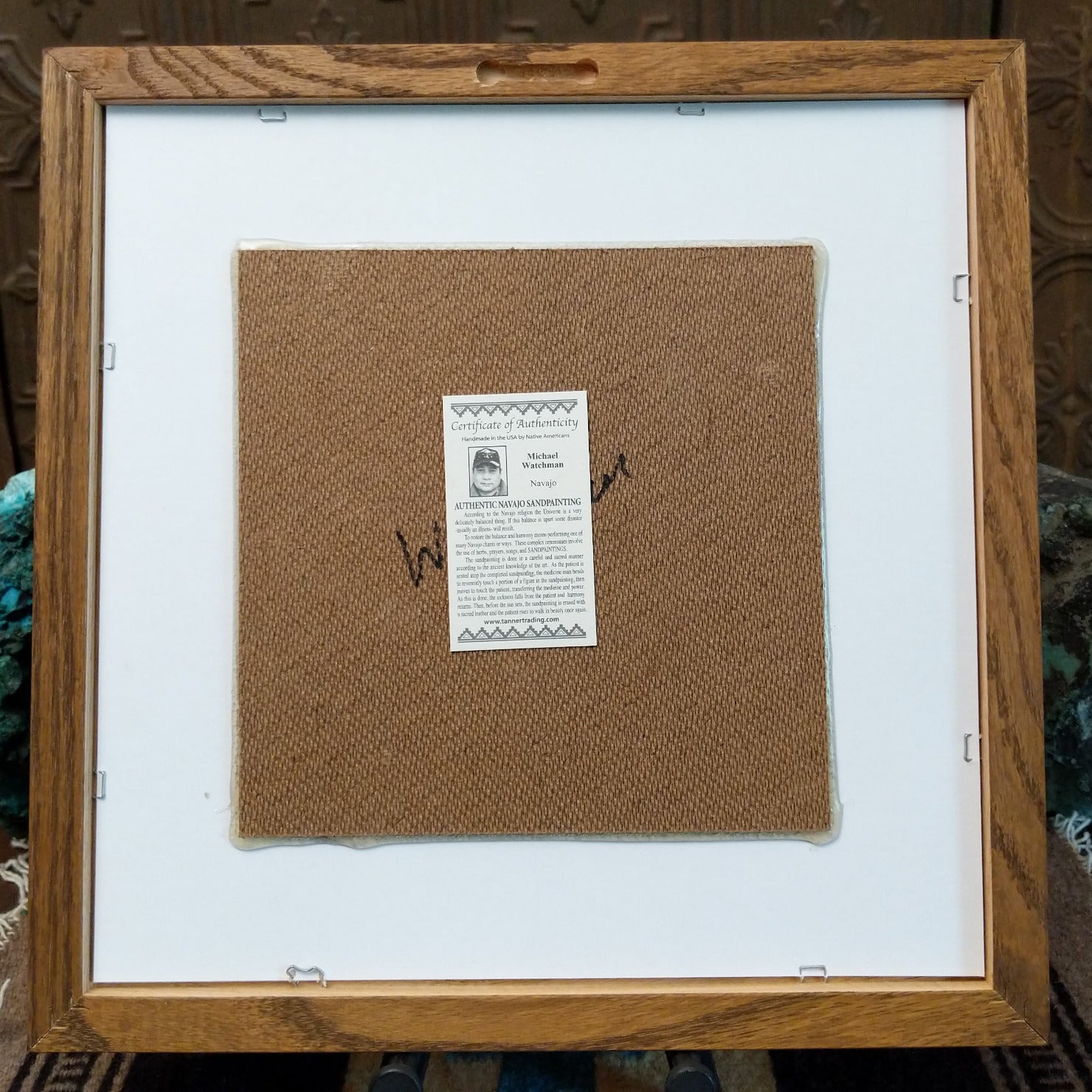Backside of the Fetish Bear Pottery sand painting, showing the Certificate of Authenticity and Artist information. 