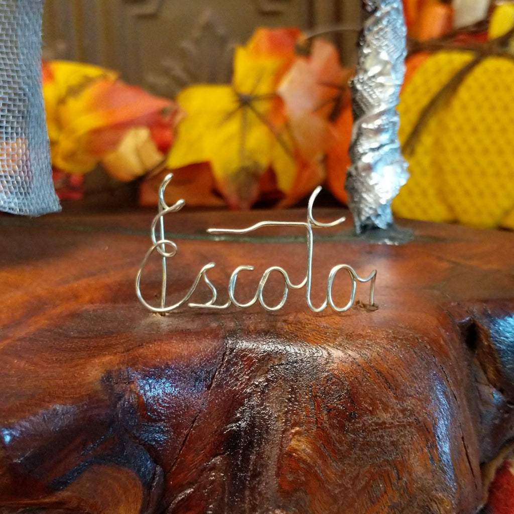 A close-up of the artisan's wire signature on the base.