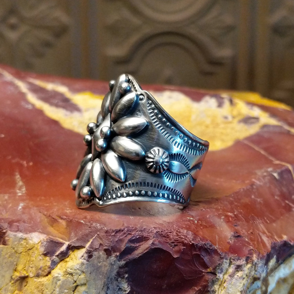 Sterling silver ring with floral detailing and dot work.