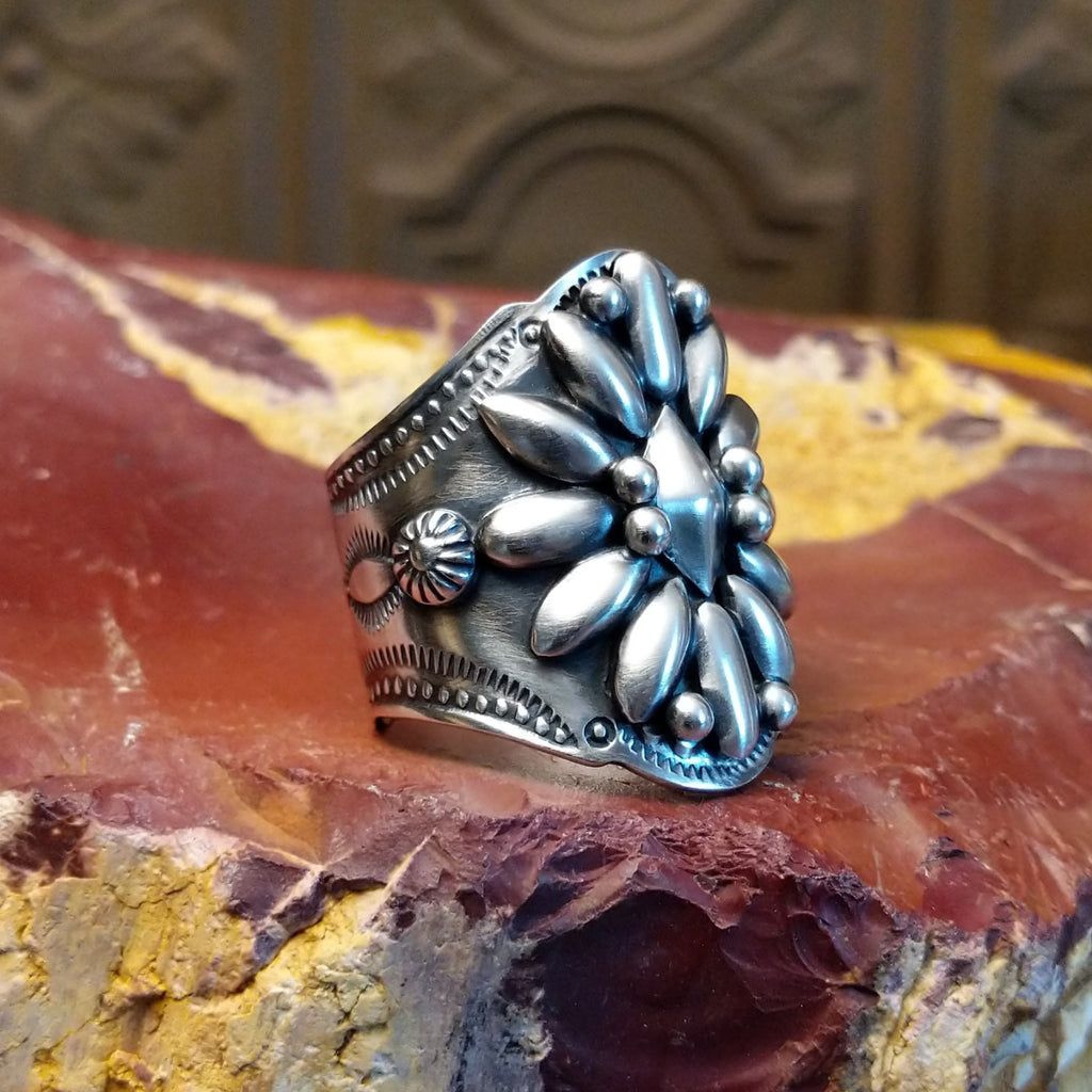 Sterling silver ring with floral detailing and dot work.