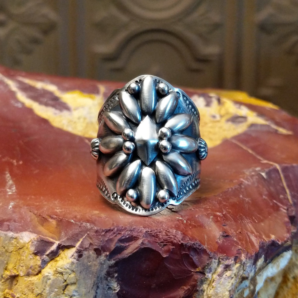 Sterling silver ring with floral detailing and dot work.