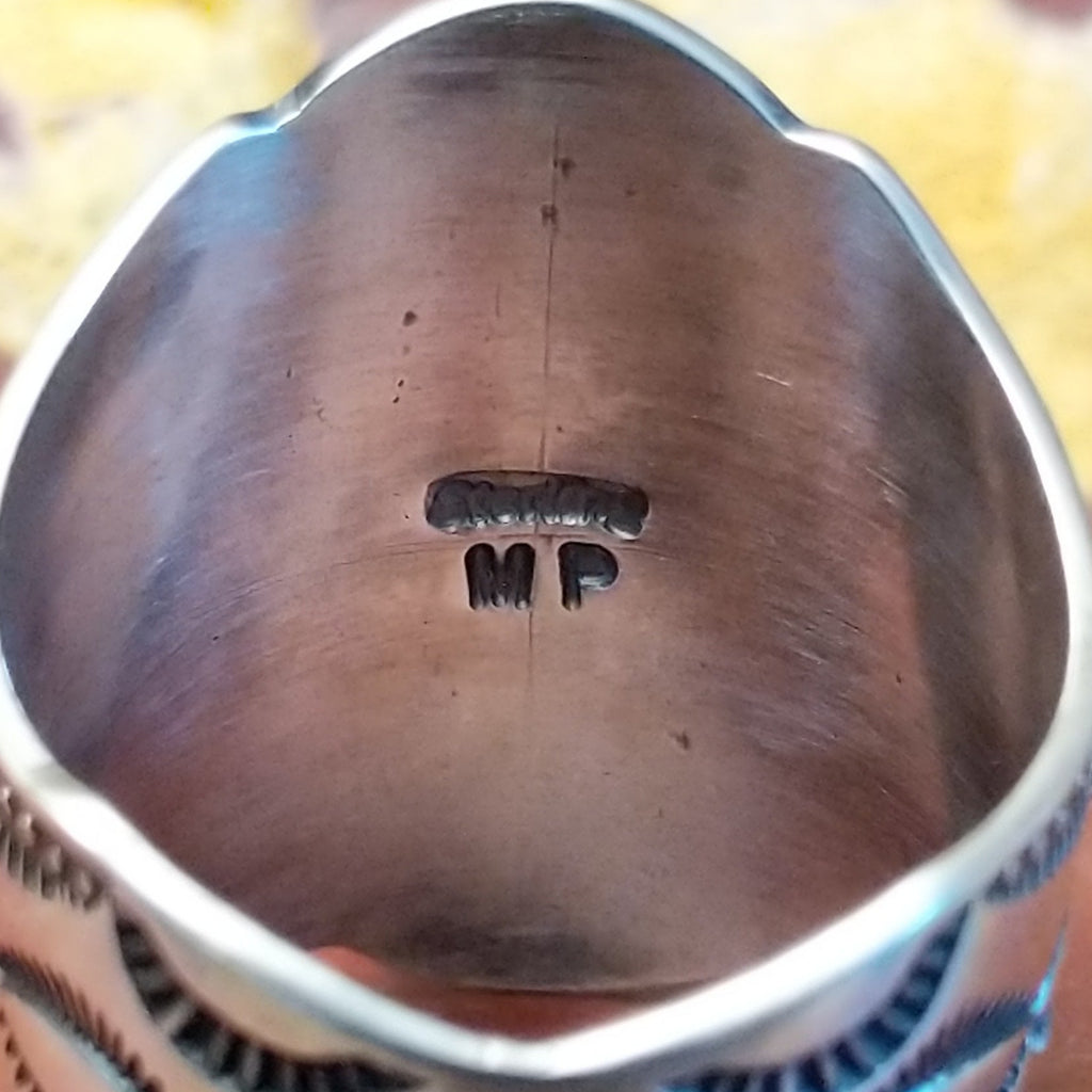 The artisan's signature is found on the interior of the ring.