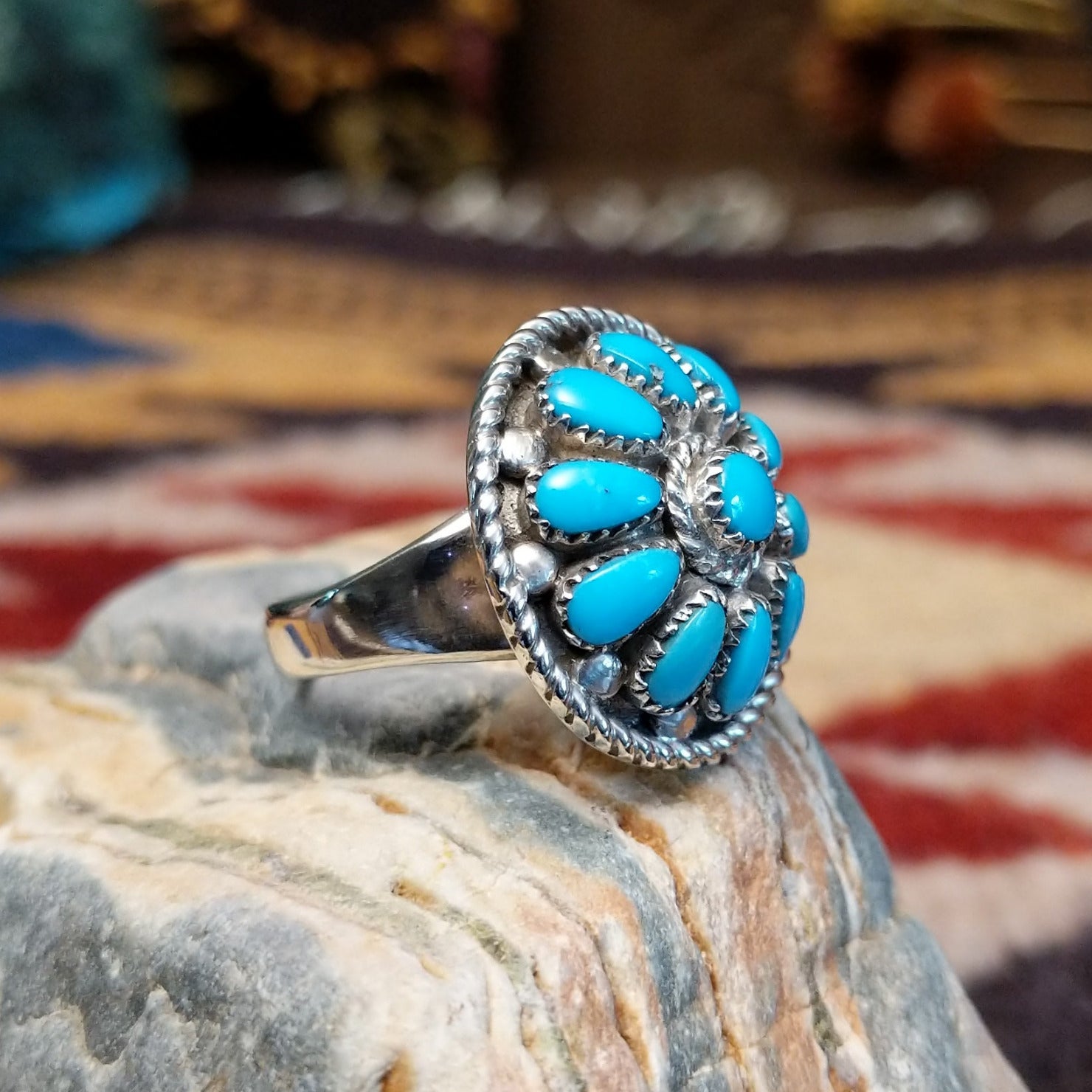 Handcrafted Navajo sterling silver ring by Lucy Jake featuring a turquoise stone with floral inspired traditional Southwestern design.  Side view.