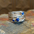 Sterling silver ring with layered, wiry band and lapis set in the bezels.