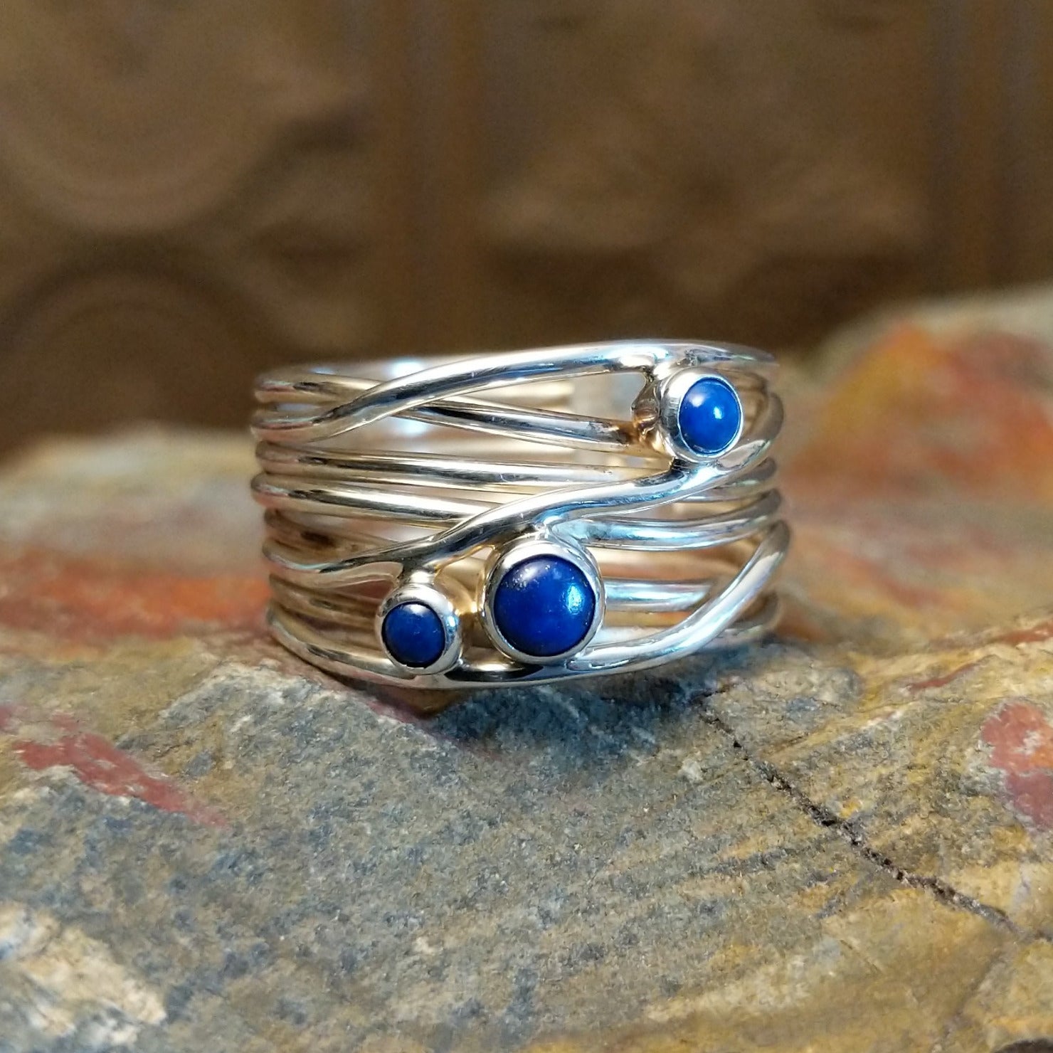 Sterling silver ring with layered, wiry band and lapis set in the bezels.