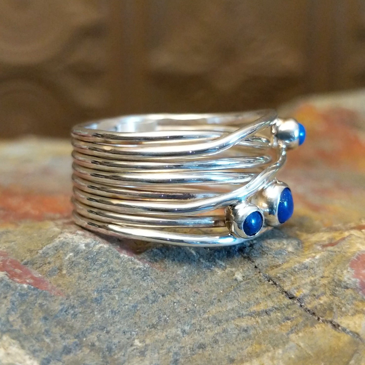 Sterling silver ring with layered, wiry band and lapis set in the bezels.