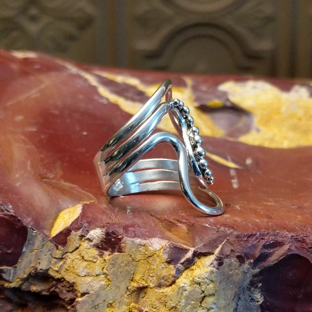 Sterling silver ring with a layered, flowing effect and dot work.