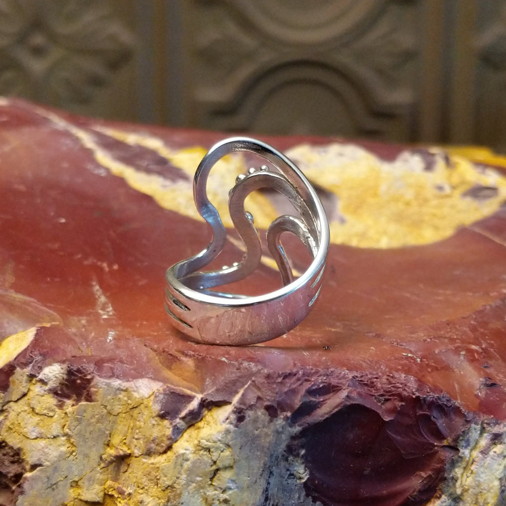 Sterling silver ring with a layered, flowing effect and dot work.