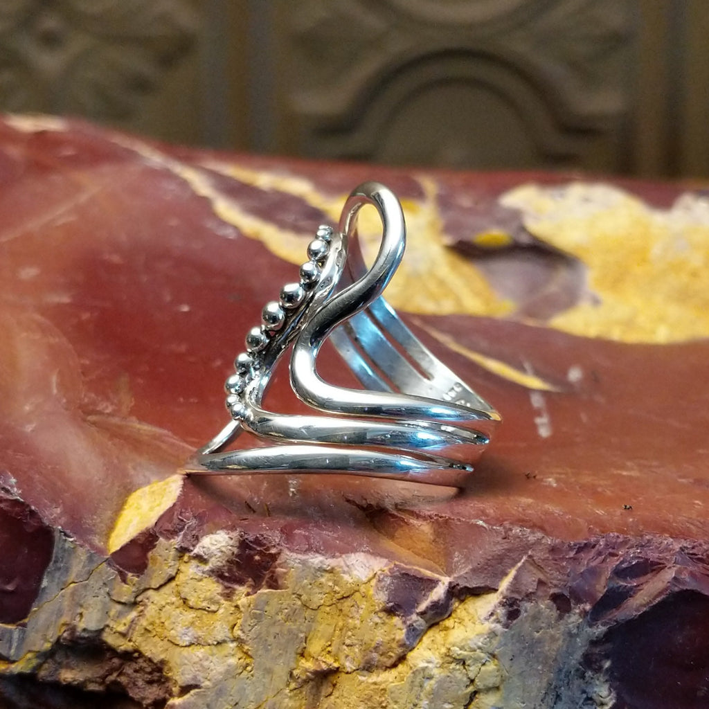 Sterling silver ring with a layered, flowing effect and dot work.