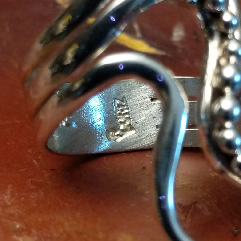 Artisan's stamp is found on the interior of the ring.