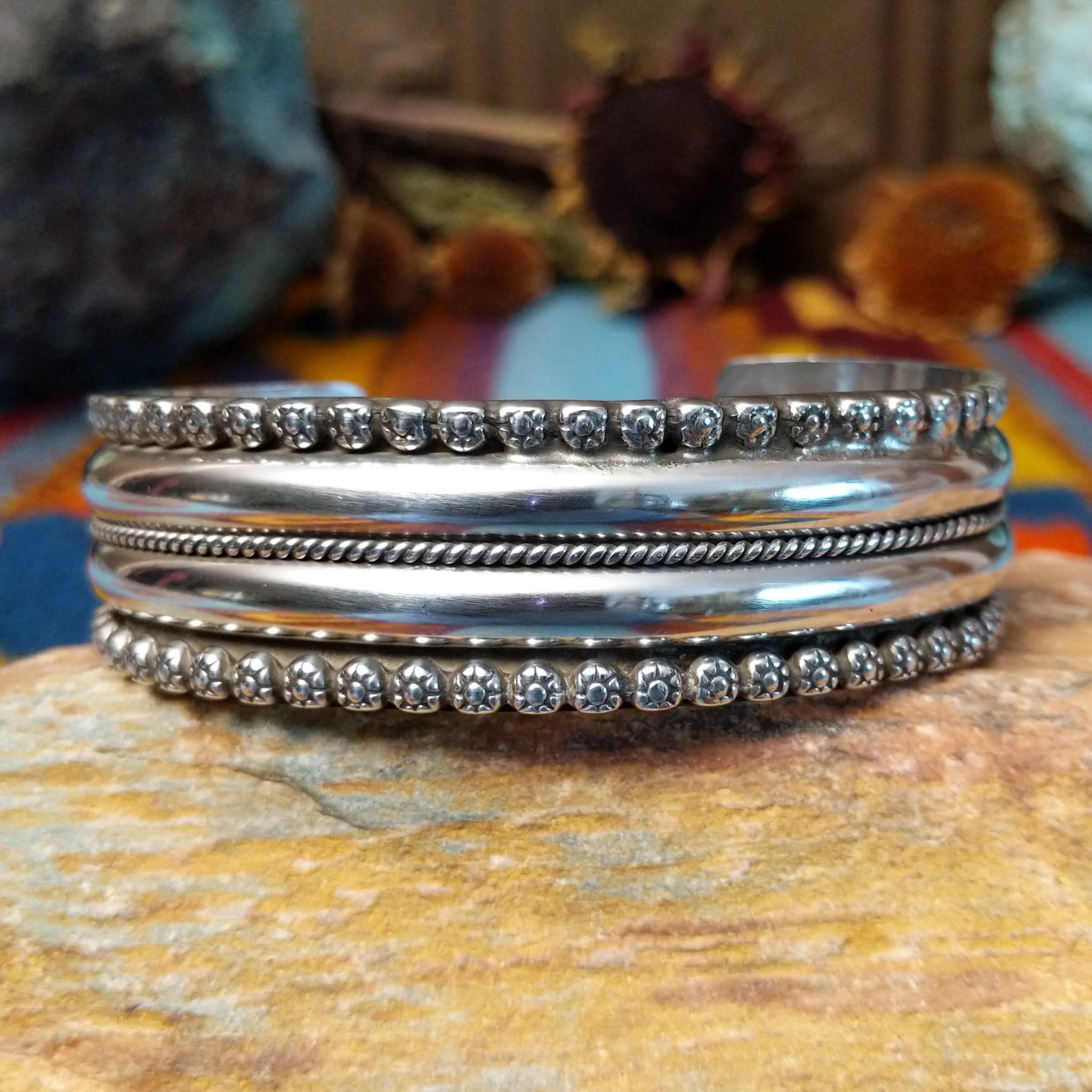 Wide silver cuff by Marc Antia with polished bands, twisted wire detail, and fluted silver borders.