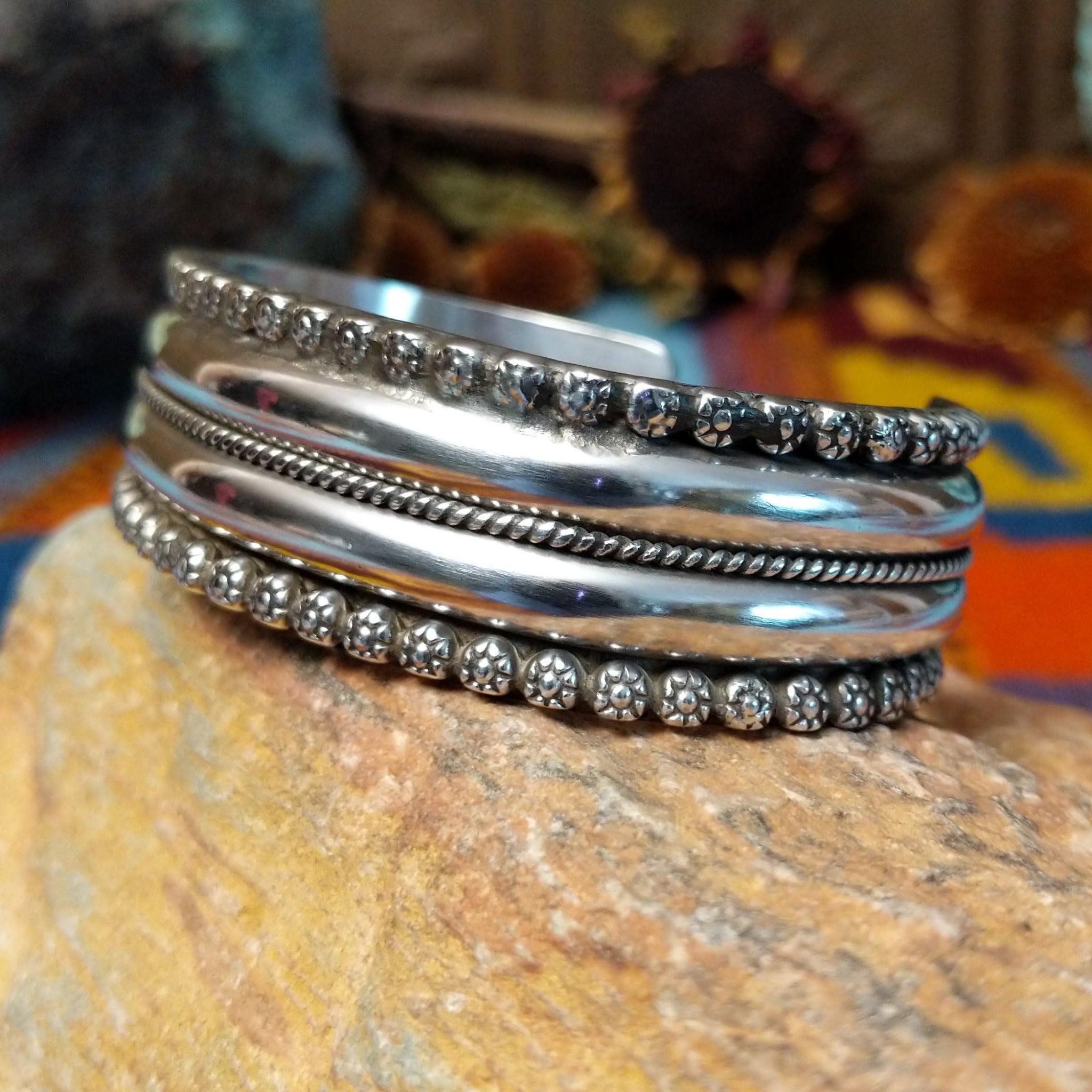 Wide silver cuff by Marc Antia with polished bands, twisted wire detail, and fluted silver borders.