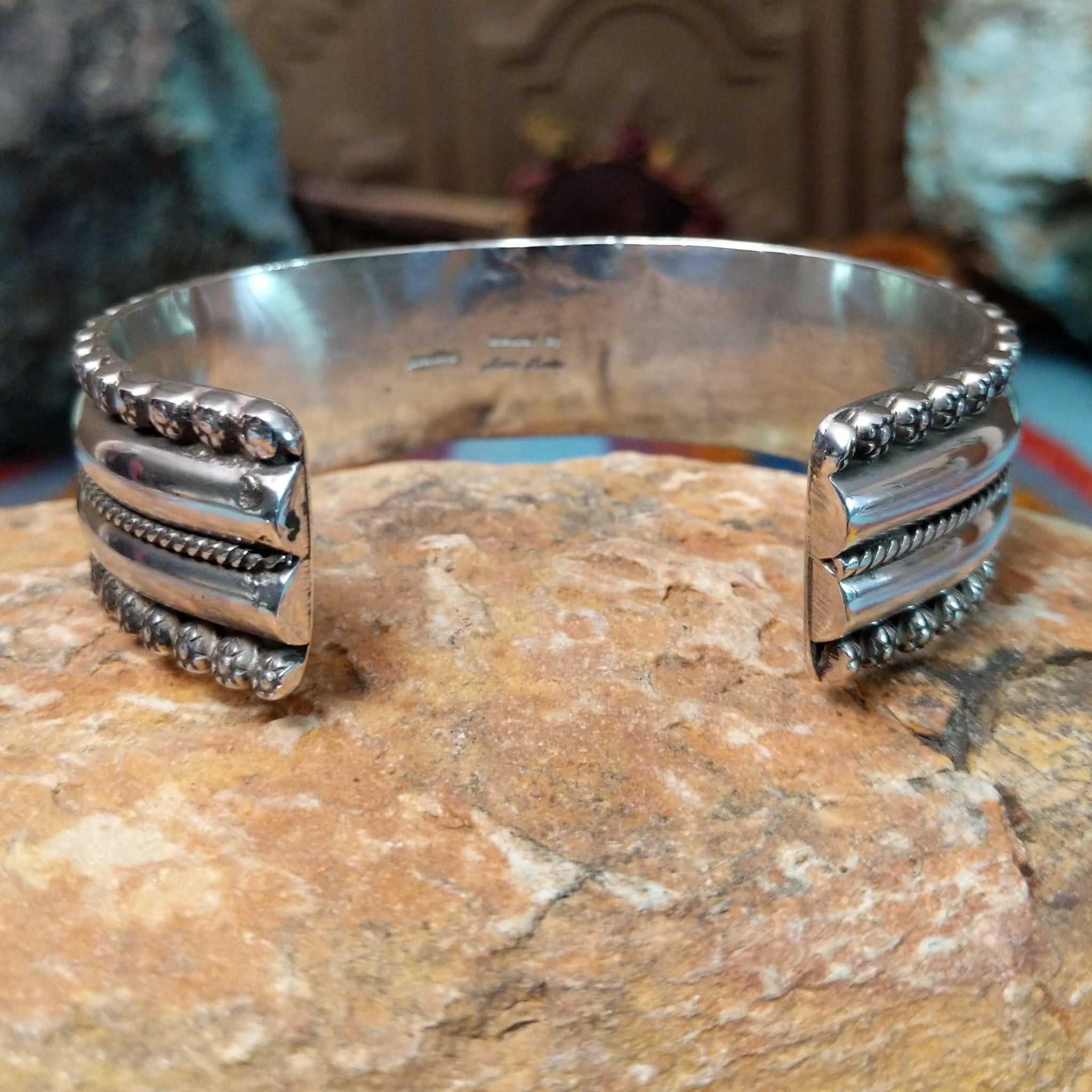 Wide silver cuff by Marc Antia with polished bands, twisted wire detail, and fluted silver borders.