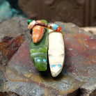 Zuni fox pair fetish carving by Jayne Quam featuring white and green stone foxes with a beaded medicine bundle.