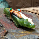 Zuni fox pair fetish carving by Jayne Quam featuring white and green stone foxes with a beaded medicine bundle.