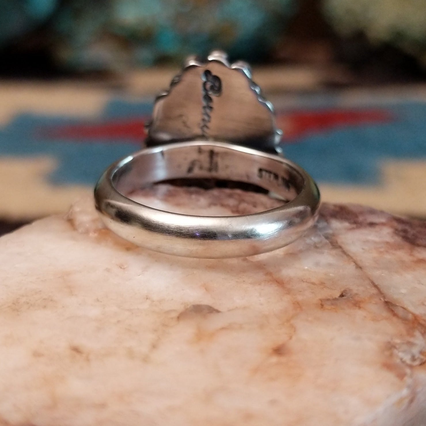 Sterling silver ring with orange oyster shell in an oval bezel.