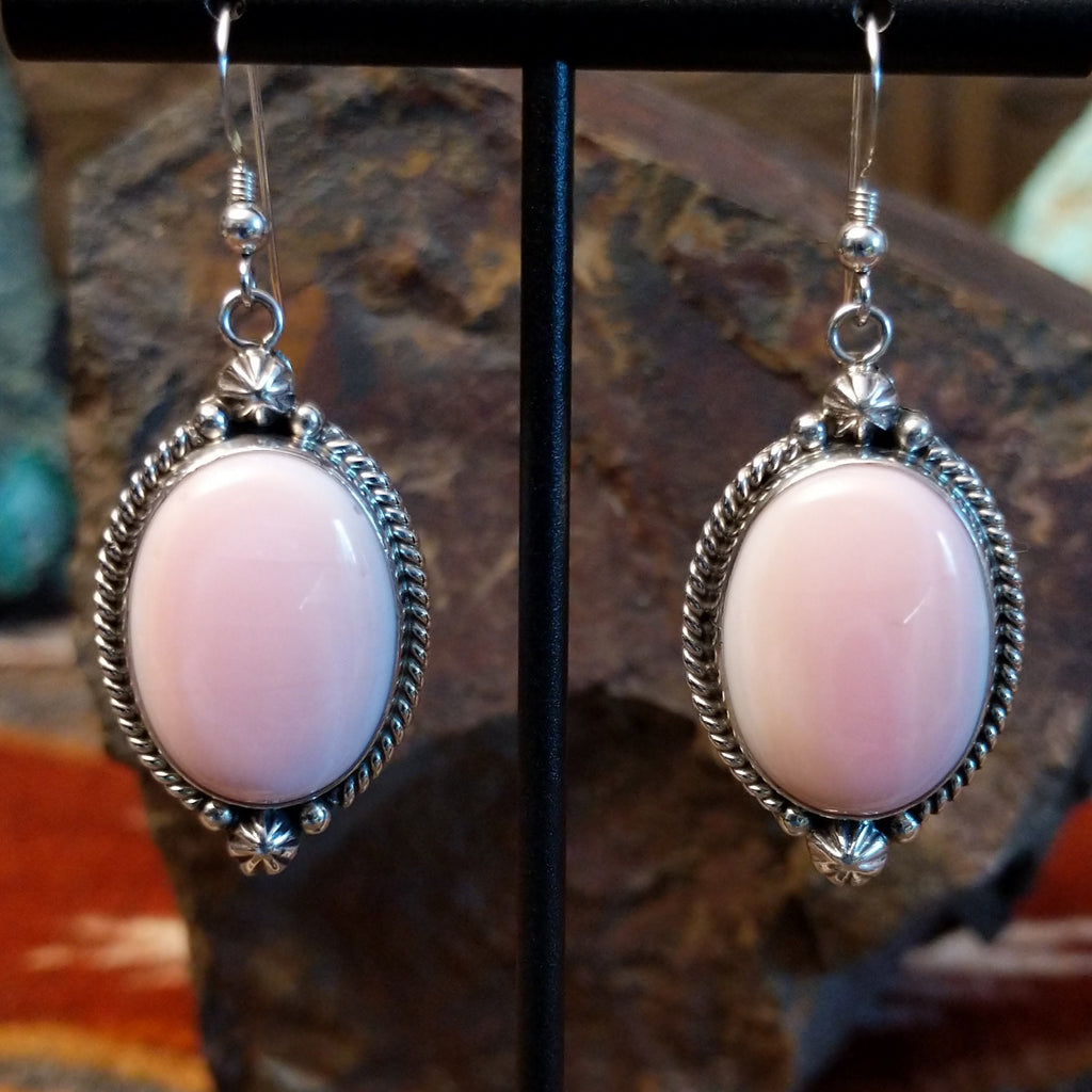 Sterling silver earrings with pink conch shell earrings set within twisted rope and dotted accent bezels.