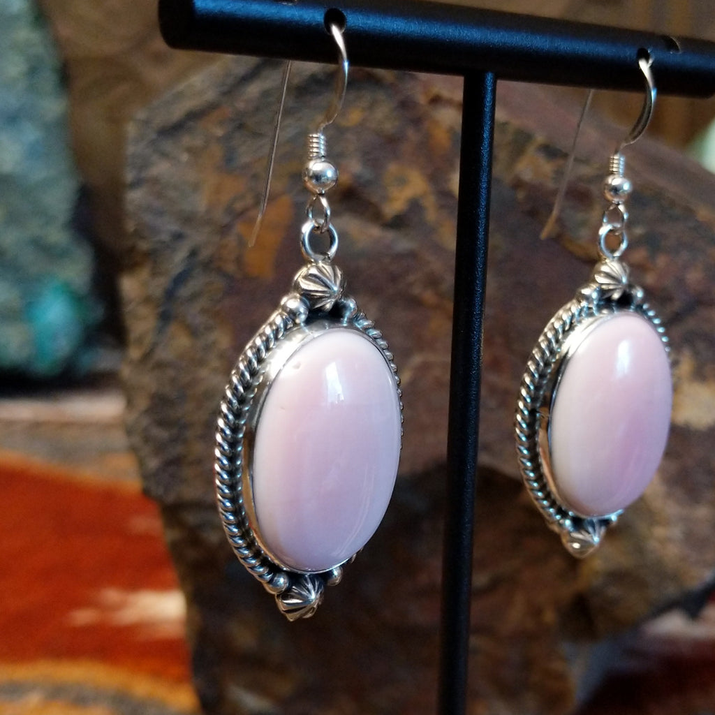 Sterling silver earrings with pink conch shell earrings set within twisted rope and dotted accent bezels.