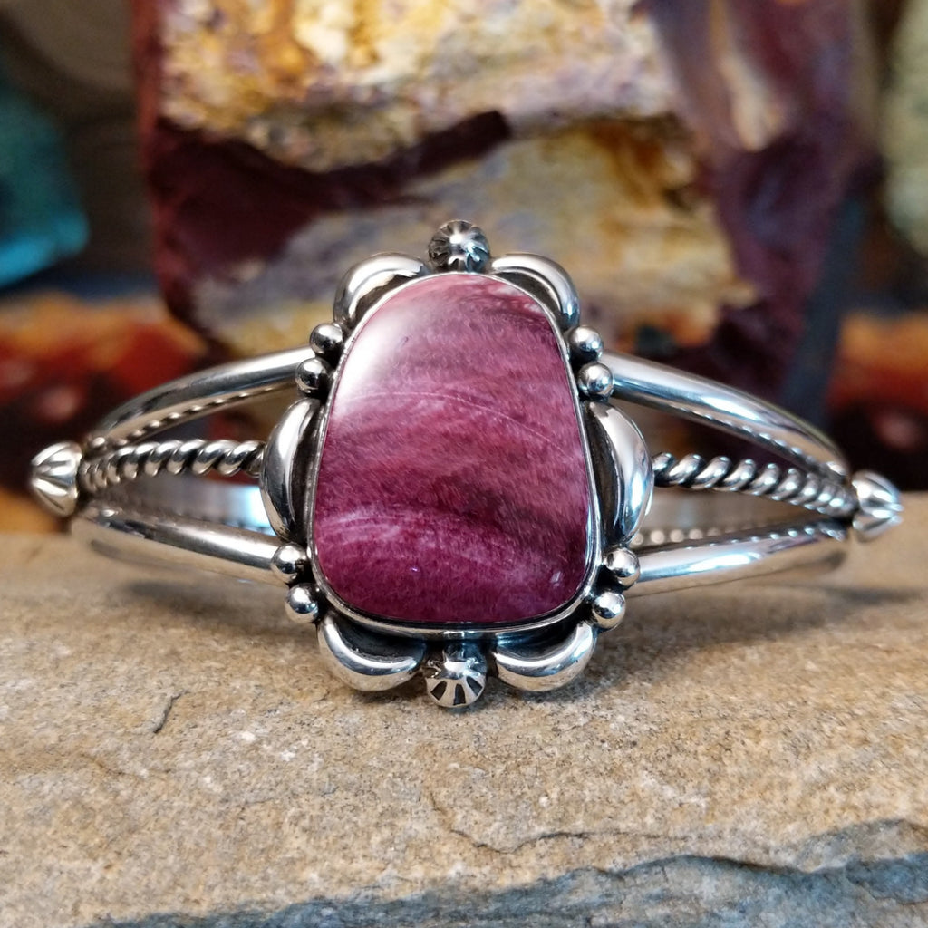 Purple spiny oyster shell cuff set in sterling silver with ornate details on the bezel.