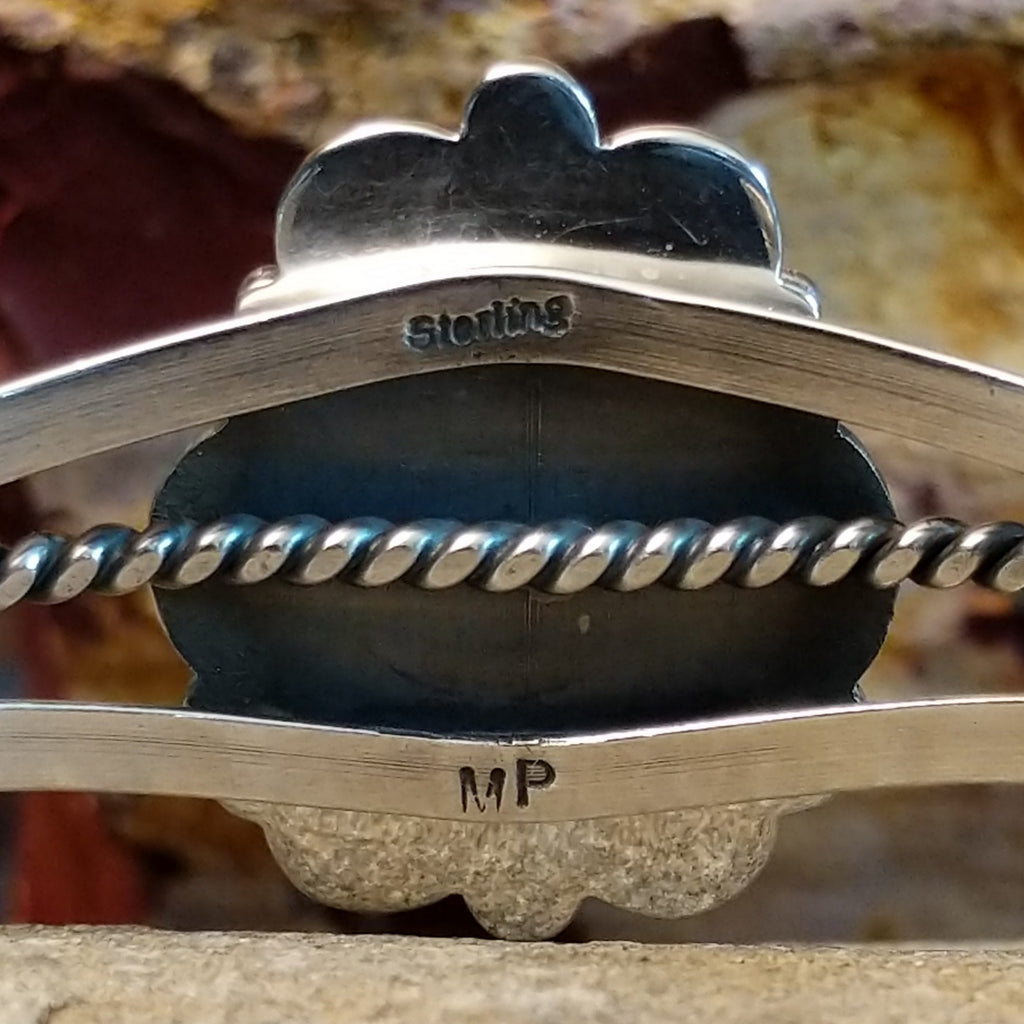 The underside of the band shows the stamped artist's signature.