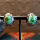 Sterling silver earrings with sonoran gold turquoise set in the bezels, framed by precise silverwork lines.