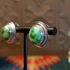 Sterling silver earrings with sonoran gold turquoise set in the bezels, framed by precise silverwork lines.