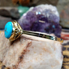 14k gold cuff by Tom Lewis with oval turquoise stone and bead accents.