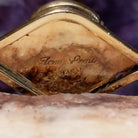 Close up of artist's stamped signature and stamped 14K, indicating 14 karat gold construction.