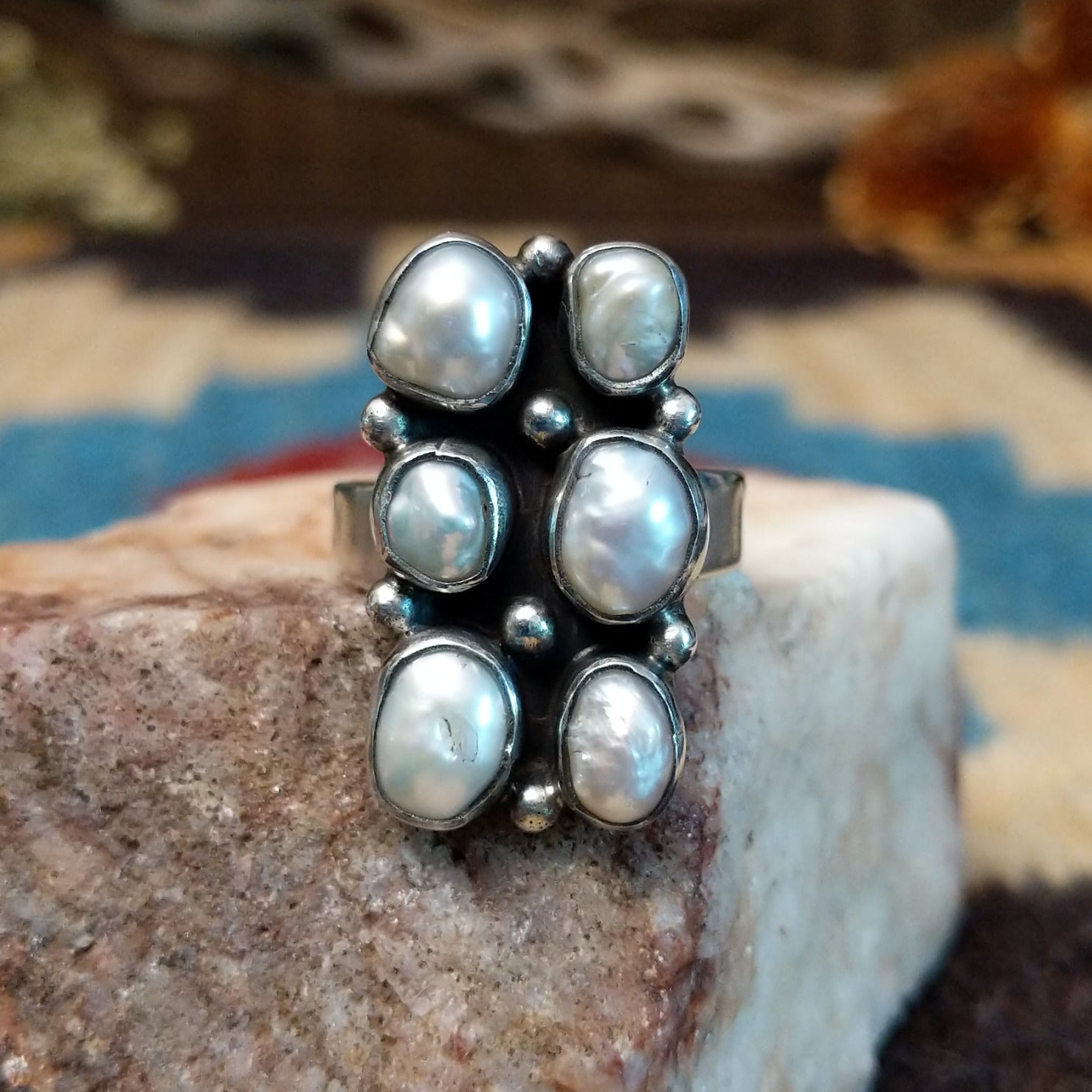 Sterling silver ring with freshwater pearl set in six bezels, framed by dotted accents.