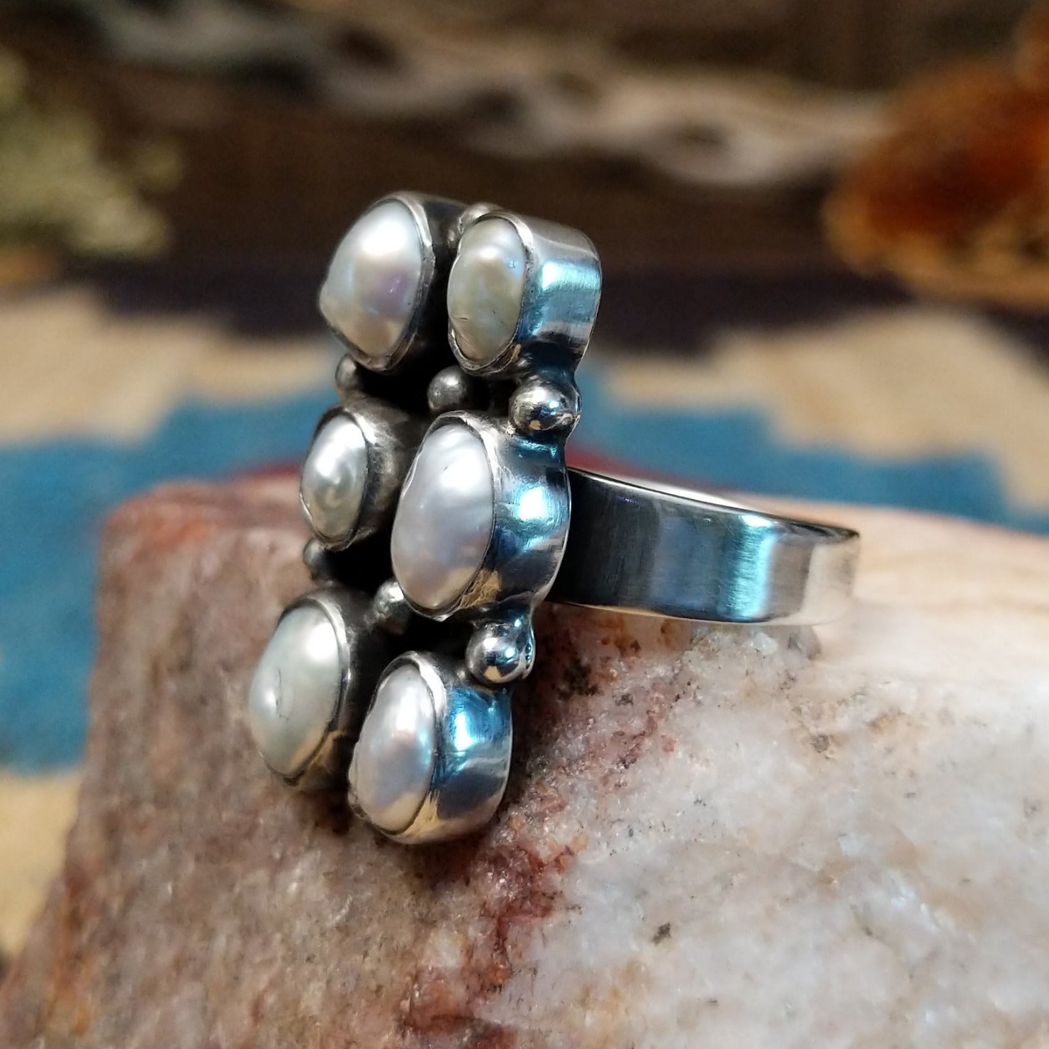 Sterling silver ring with freshwater pearl set in six bezels, framed by dotted accents.