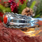 Sterling silver cuff with stamped, frilled edges and coral framed by twisted rope accent.