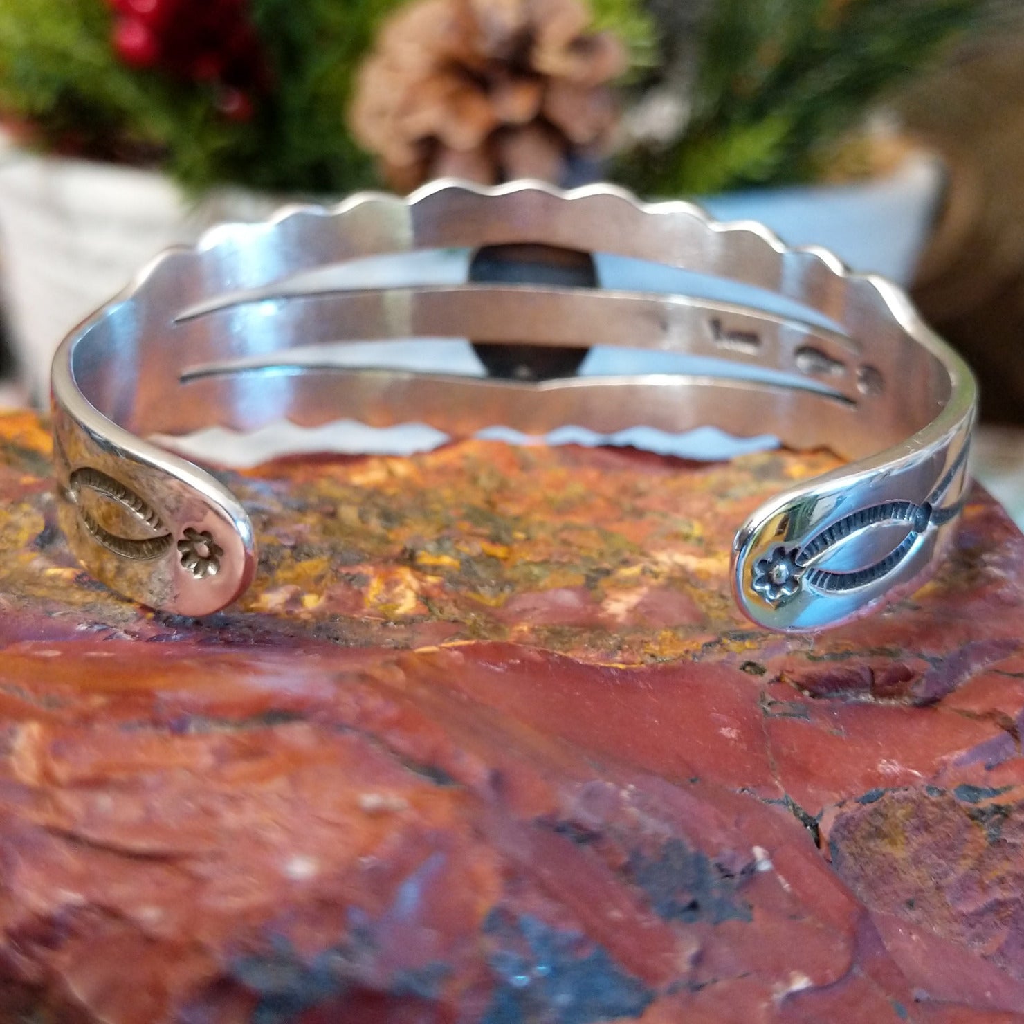 Sterling silver cuff with stamped, frilled edges and coral framed by twisted rope accent.
