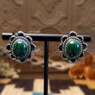 Sterling silver earrings with malachite set in bezels, framed by twisted rope accents and frilled edges.