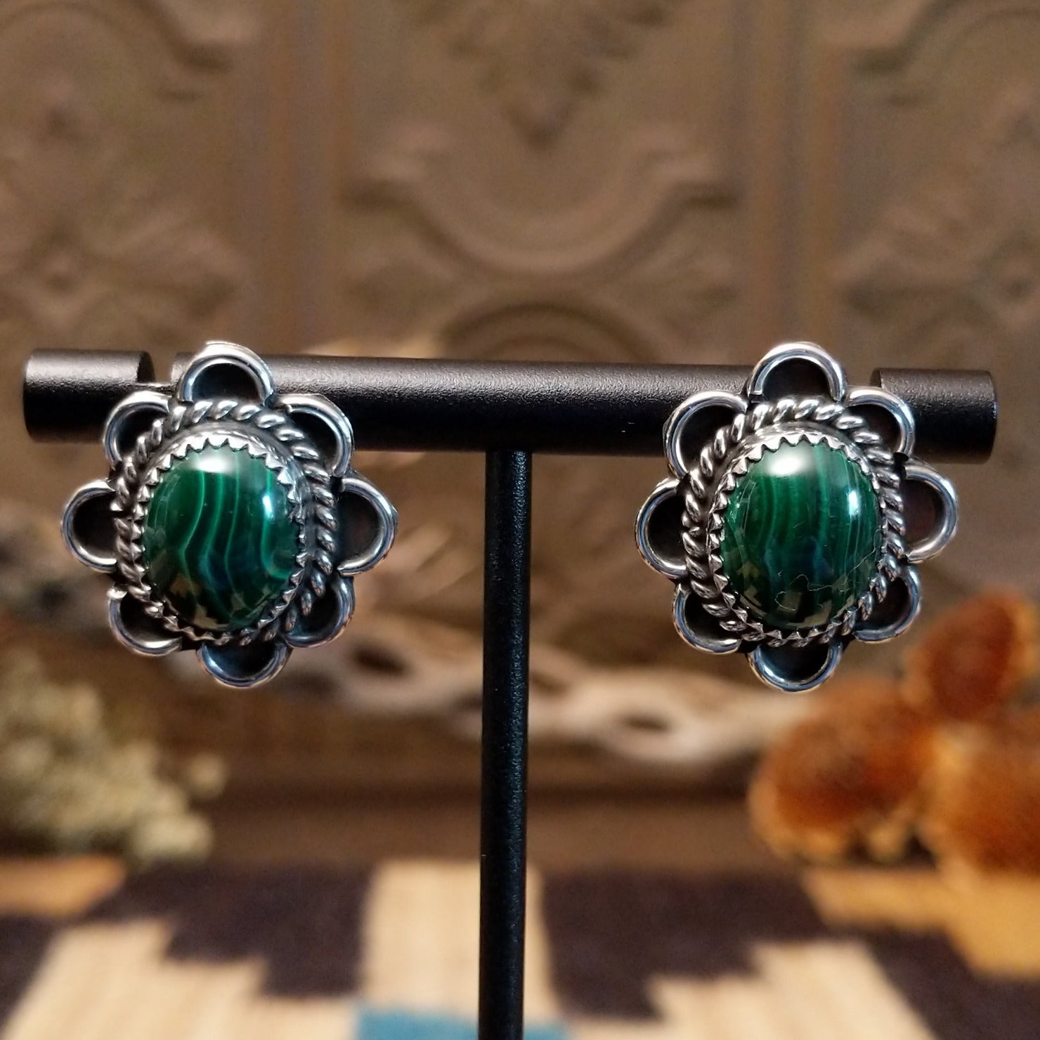 Sterling silver earrings with malachite set in bezels, framed by twisted rope accents and frilled edges.