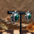Sterling silver earrings with malachite set in bezels, framed by twisted rope accents and frilled edges.