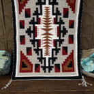 A splendid Navajo rug handmade by artist Laberta Yazzie with wools dyed an assortment of exquisite colors. The rich red holds beauty throughout the many interesting designs. A striking piece of art for home decor!