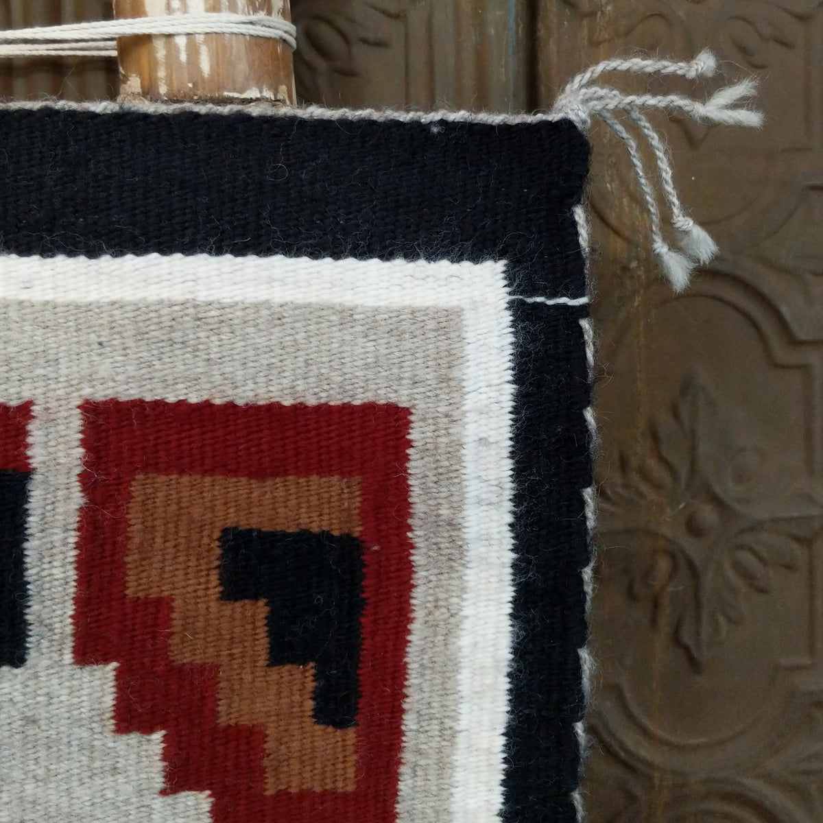A splendid Navajo rug handmade by artist Laberta Yazzie with wools dyed an assortment of exquisite colors. The rich red holds beauty throughout the many interesting designs. A striking piece of art for home decor!