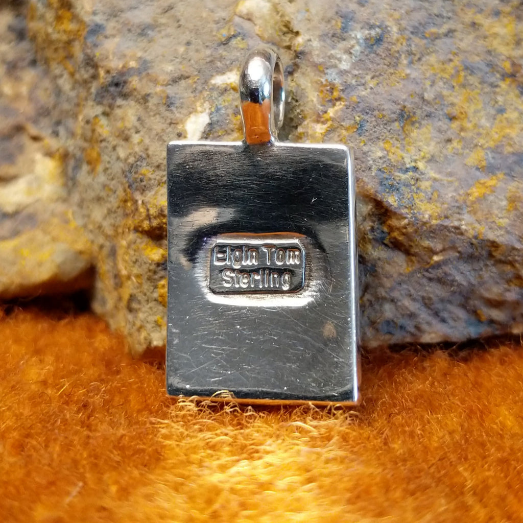 The back features the artisan's signature on the back.