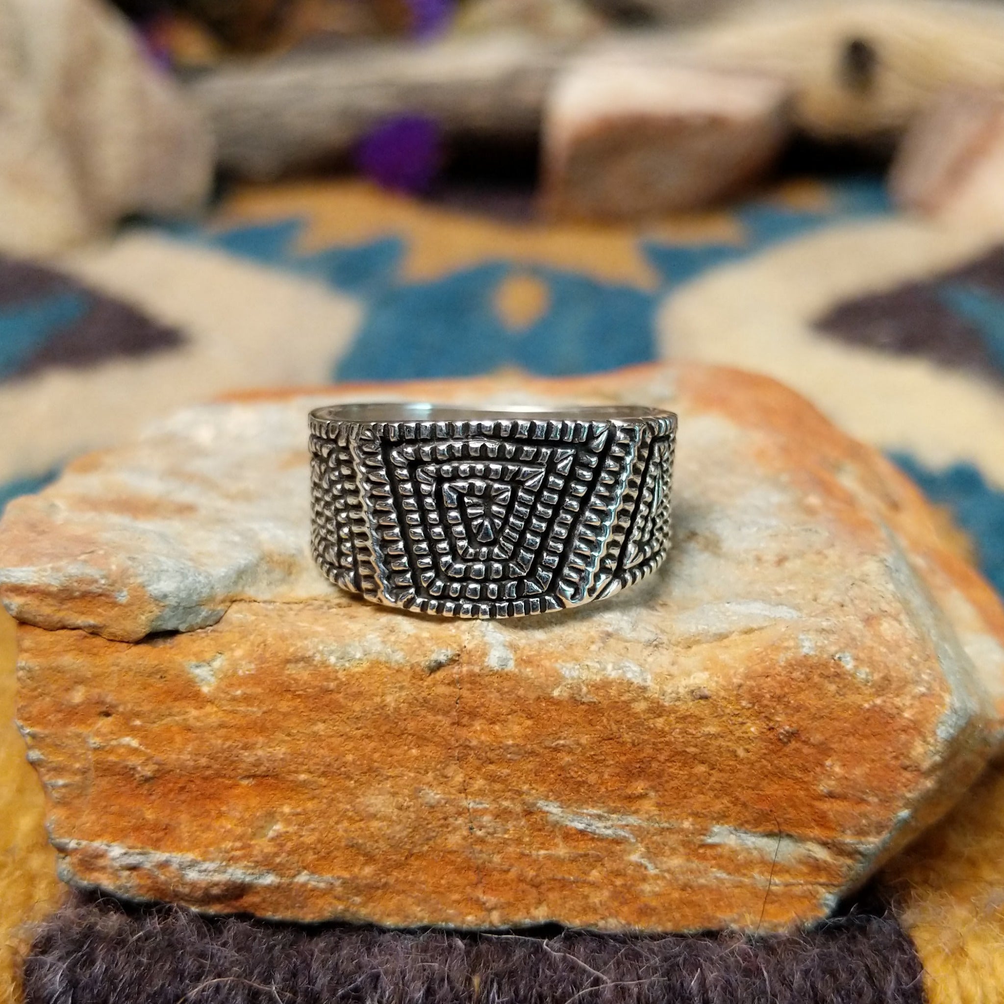 Sterling silver geometric band ring by Elgin Tom with hand-stamped spiral patterns.