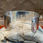 Sterling silver cuff with geometrical stamped centerpiece and polished finish.