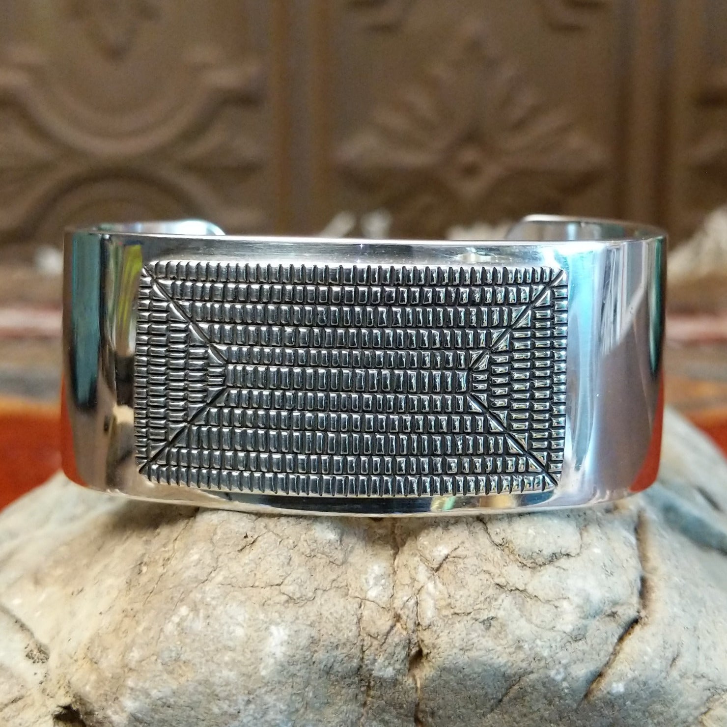 Sterling silver cuff with geometrical stamped centerpiece and polished finish.