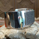 Sterling silver cuff with geometrical stamped centerpiece and polished finish.