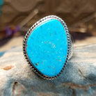 Sterling silver ring with Kingman turquoise set in the gibbous-shaped bezel, framed by twisted rope accents.