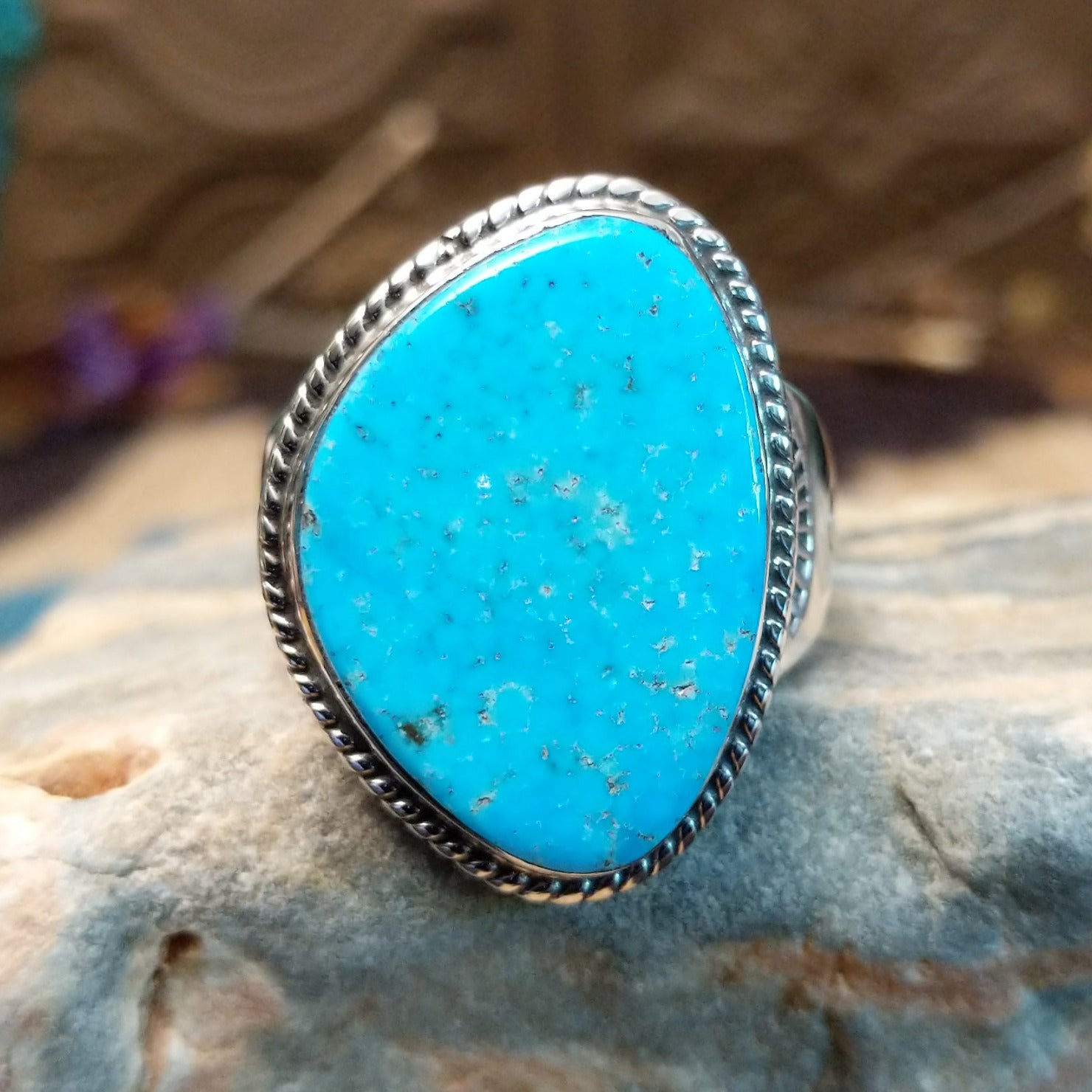 Sterling silver ring with Kingman turquoise set in the gibbous-shaped bezel, framed by twisted rope accents.
