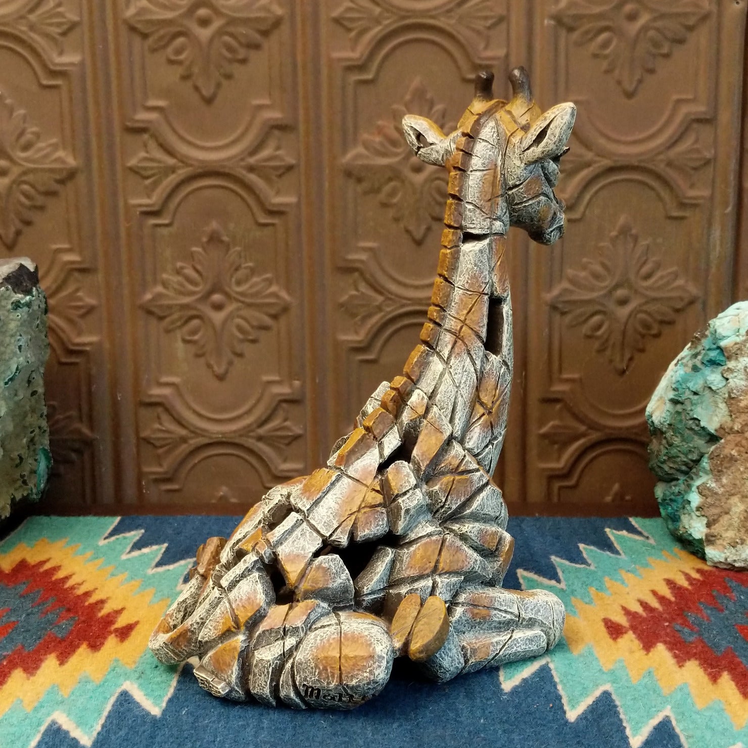 Cast marble of a giraffe calf painted in it's tradition orange and tan coloring.