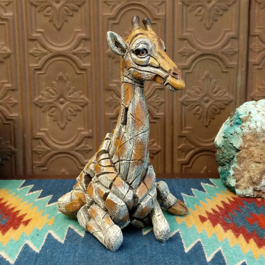 Cast marble of a giraffe calf painted in it's tradition orange and tan coloring.